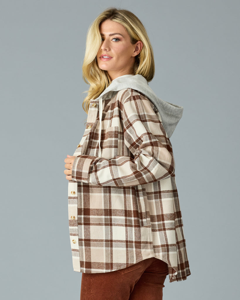 Woman in a tan plaid buttondown with a sweater hood attached