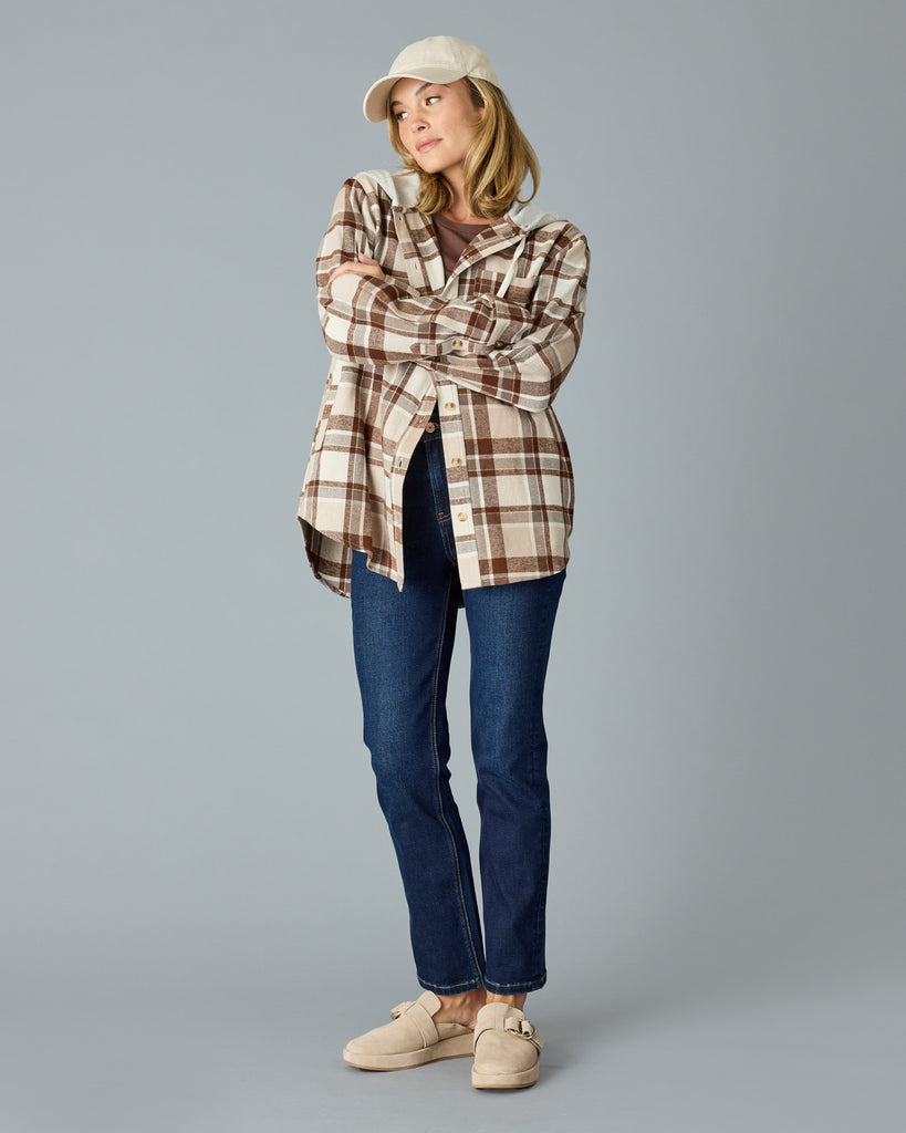 Woman in a tan plaid buttondown with a sweater hood attached