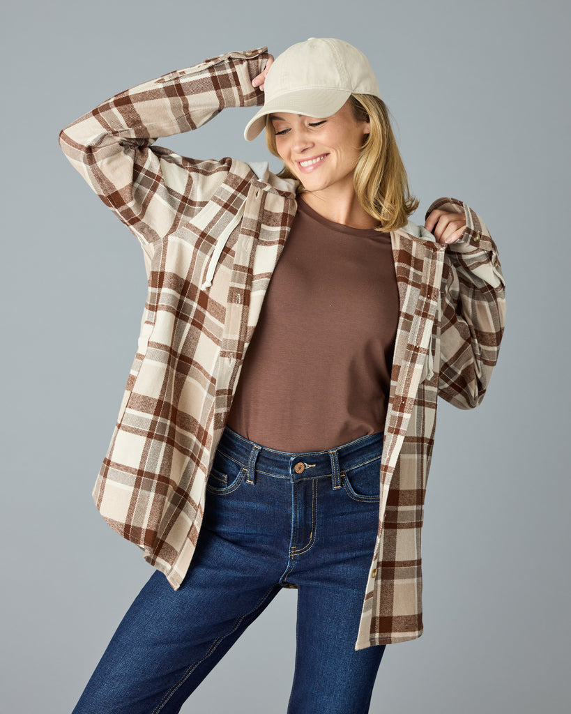 Woman in a tan plaid buttondown with a sweater hood attached