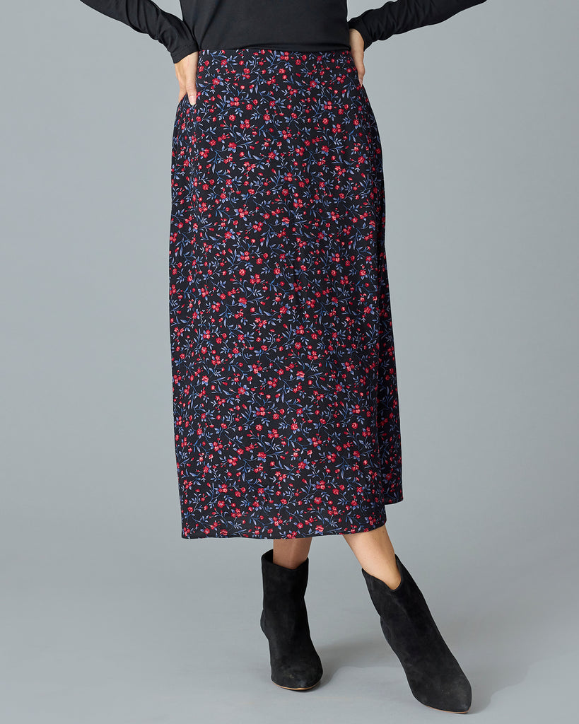 Woman in a black with floral print midi length skirt