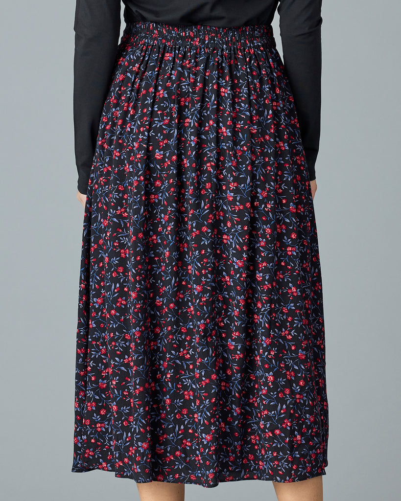 Woman in a black with floral print midi length skirt