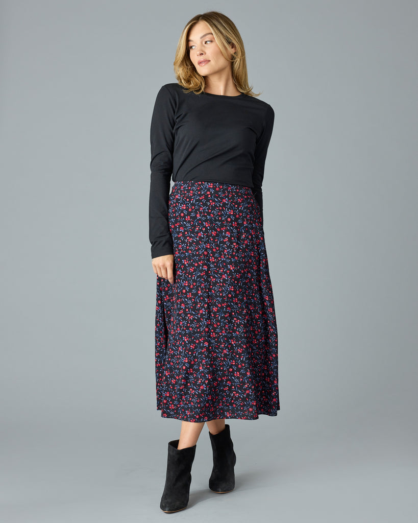 Woman in a black with floral print midi length skirt