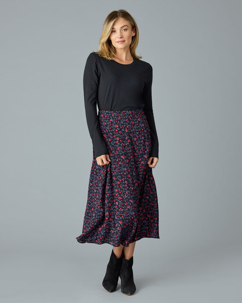 Woman in a black with floral print midi length skirt