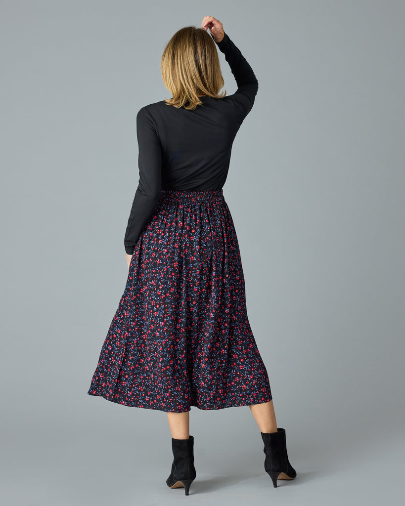 Woman in a black with floral print midi length skirt