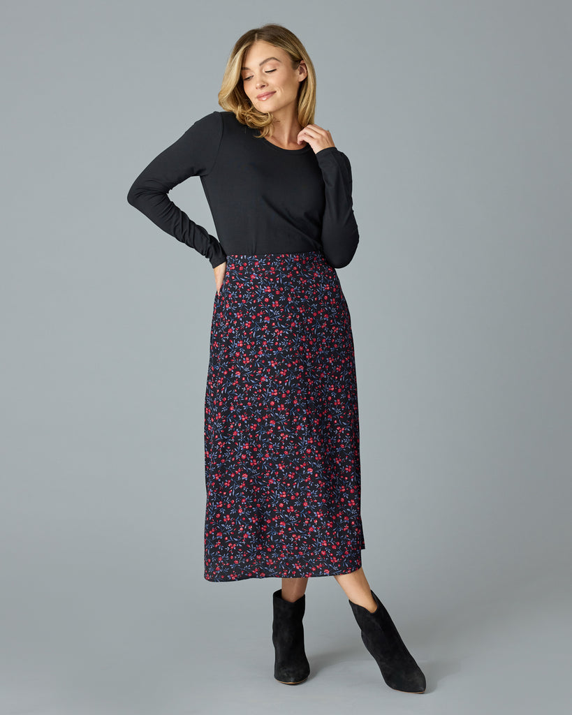 Woman in a black with floral print midi length skirt