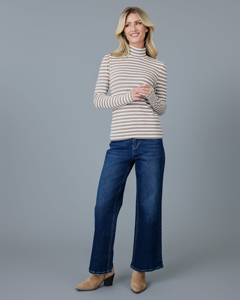 Woman in a brown and white striped, long sleeve, turtleneck