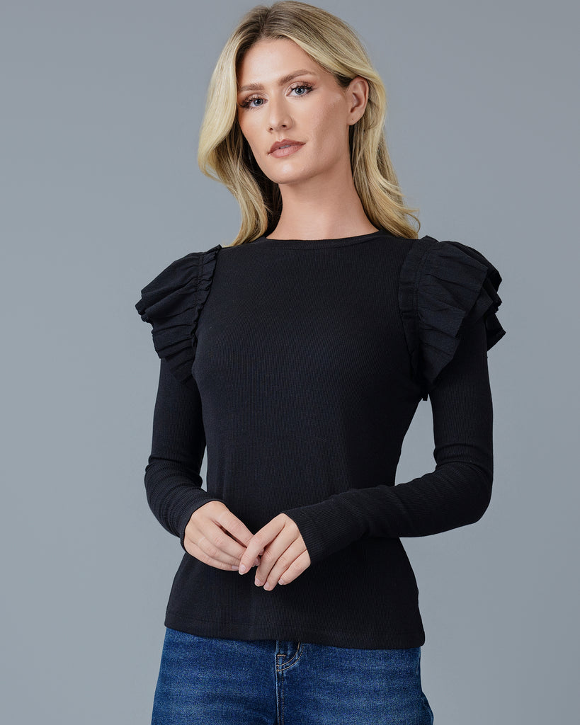 Woman in a black long sleeve t-shirt with double ruffles on shoulders