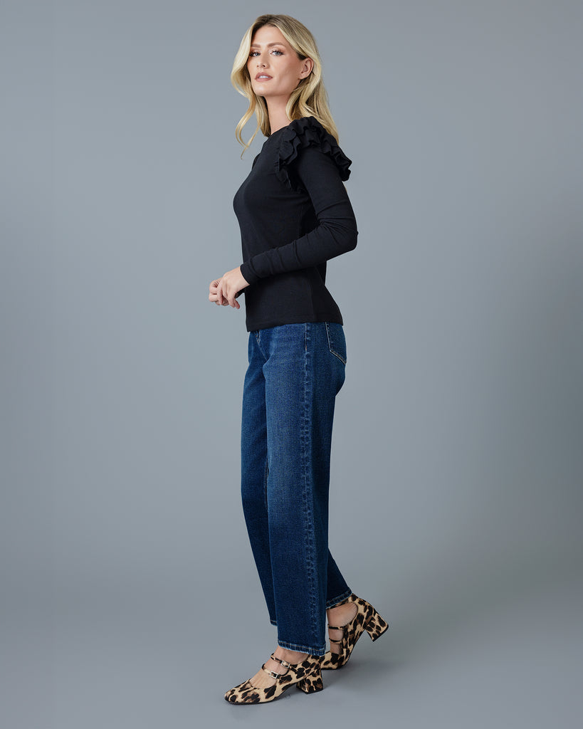 Woman in a black long sleeve t-shirt with double ruffles on shoulders