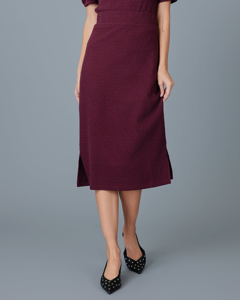 Woman in a plum colored midi length sheath skirt