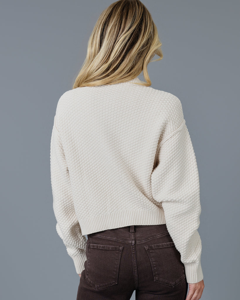 Woman in a beige long sleeve textured cardigan