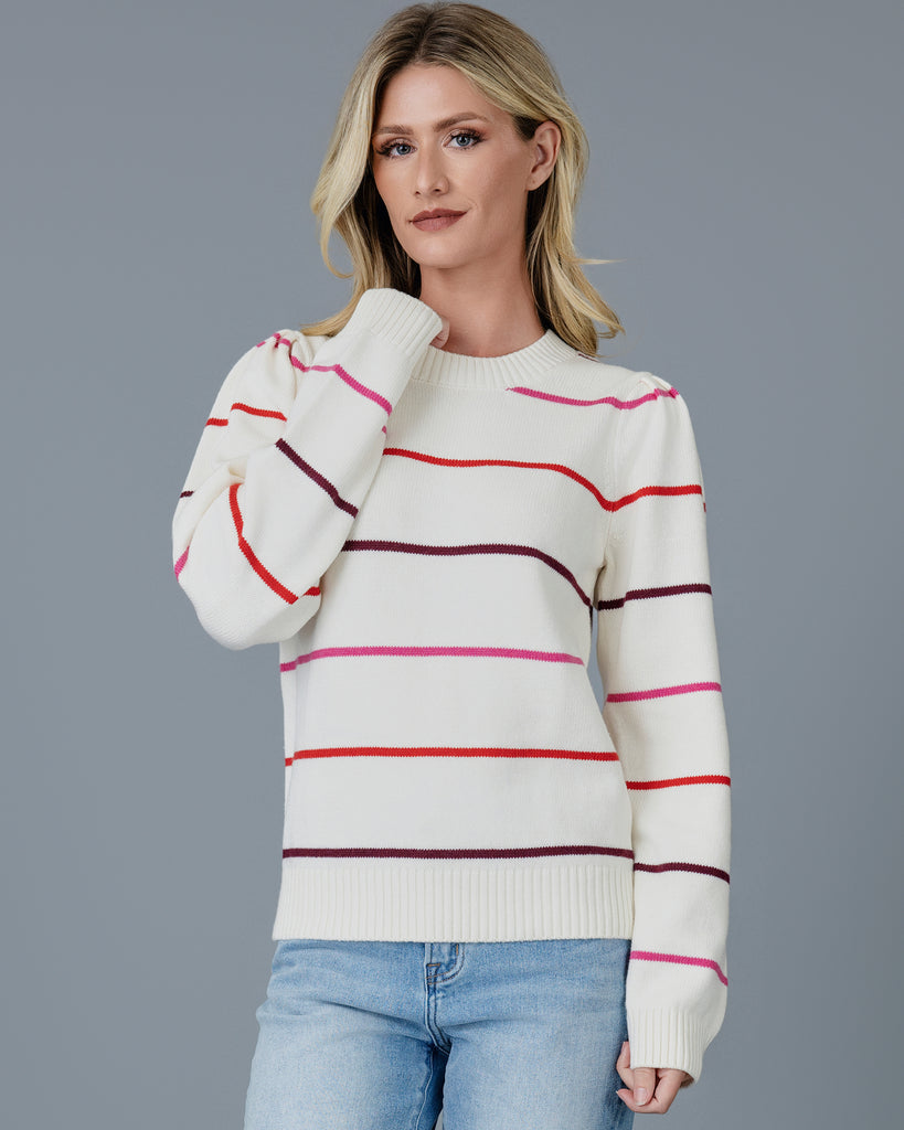 Woman in a white with red, white and purple striped long sleeve pullover sweater