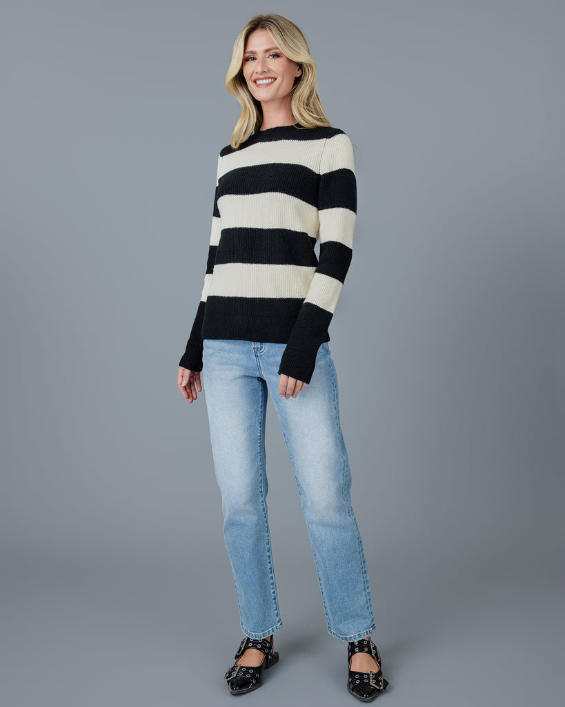 Woman in a black and white striped long sleeve sweater