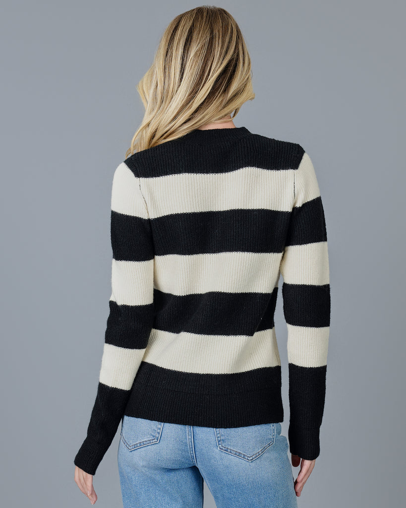 Woman in a black and white striped long sleeve sweater