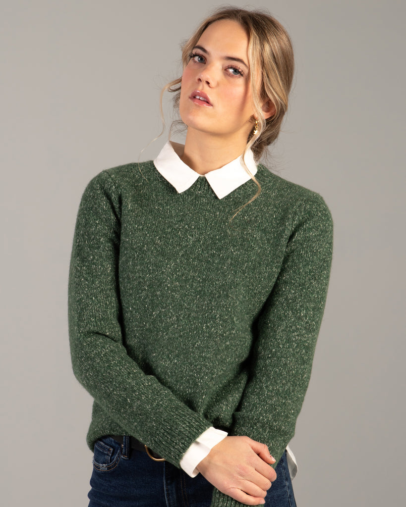 Model wearing a green speckled long sleeve crew neck pullover sweater.