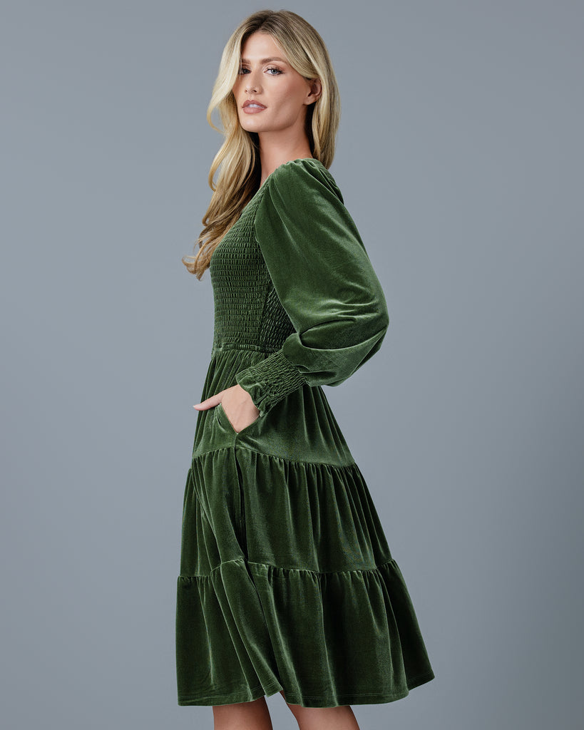 Woman in a green velvet long sleeve knee-length dress