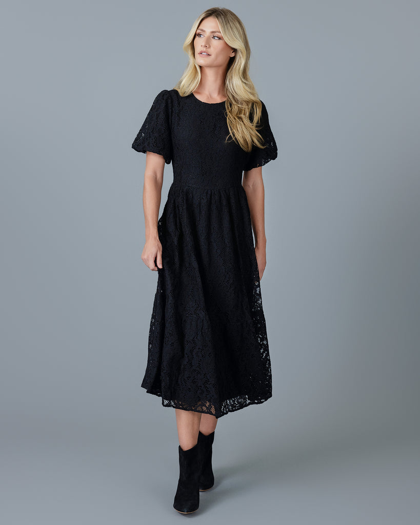 Woman in a black short sleeve midi-length lace dress