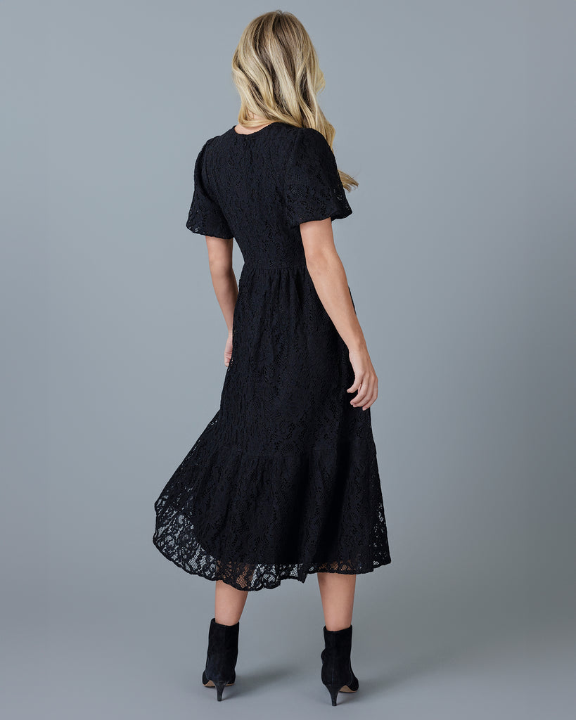 Woman in a black short sleeve midi-length lace dress