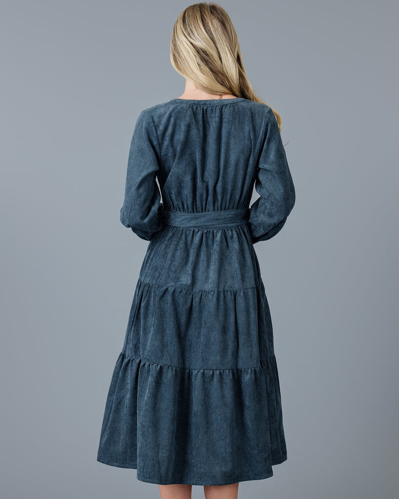 Woman in a blue velvet-y corduroy long sleeve midi dress