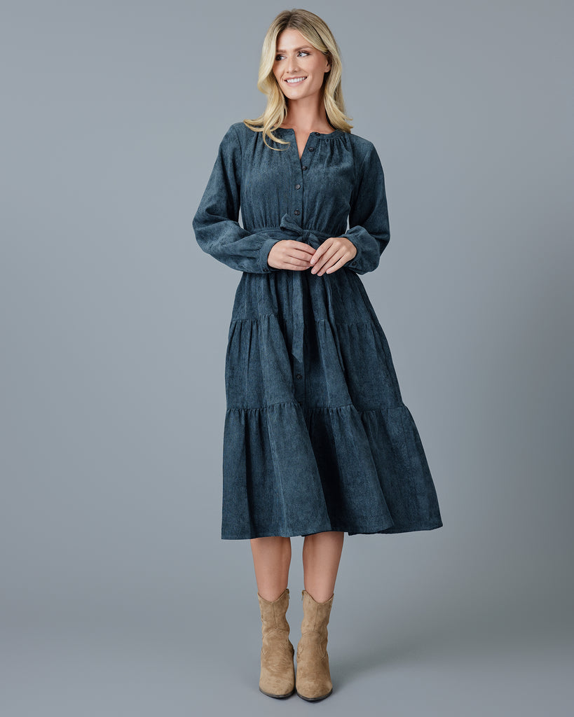 Woman in a blue velvet-y corduroy long sleeve midi dress