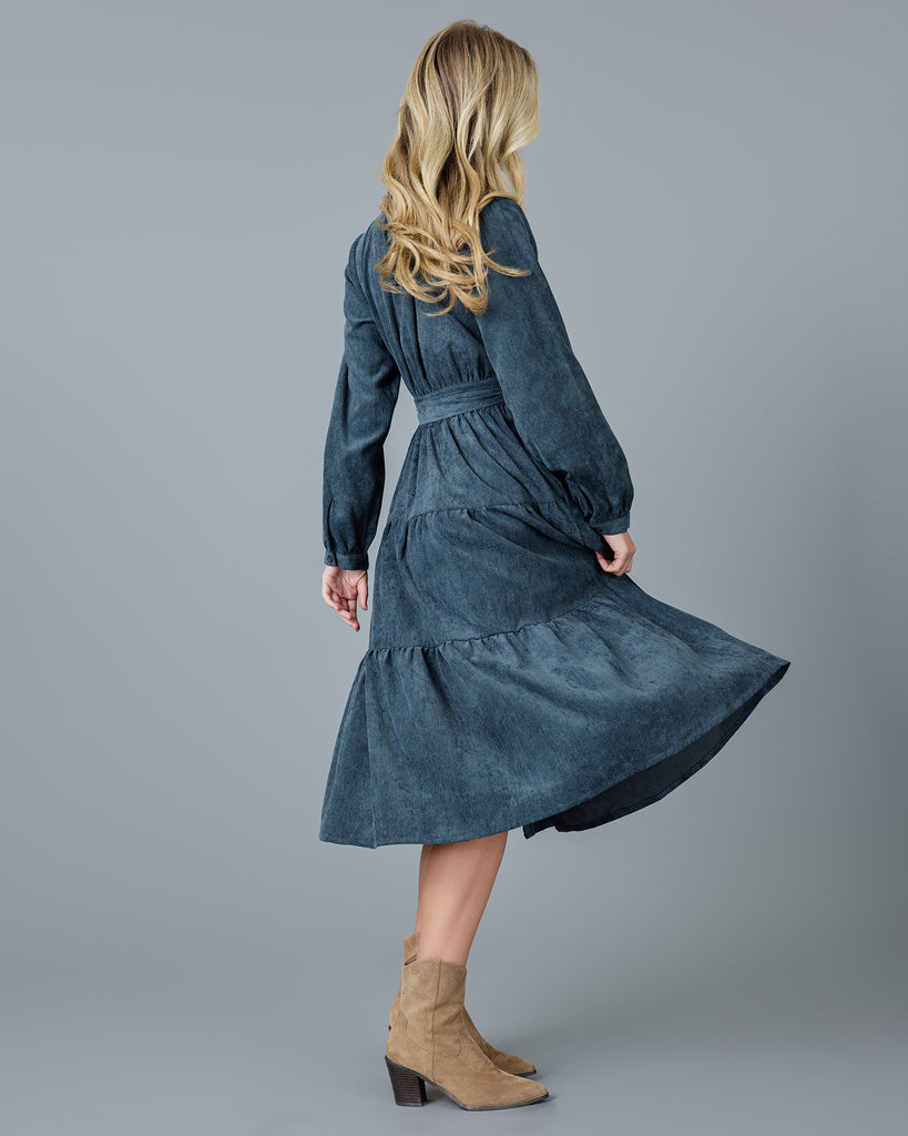 Woman in a blue velvet-y corduroy long sleeve midi dress