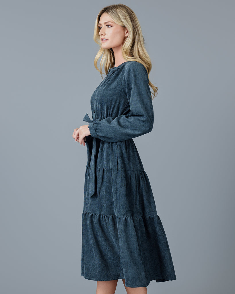 Woman in a blue velvet-y corduroy long sleeve midi dress