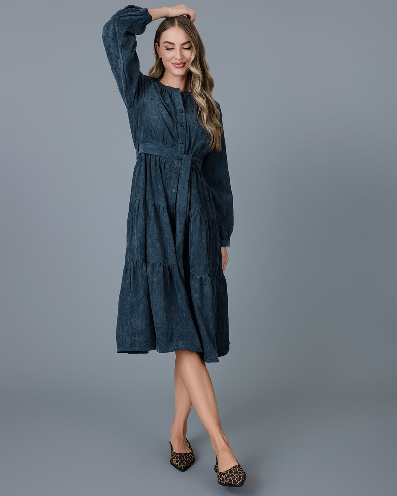 Woman in a blue velvet-y corduroy long sleeve midi dress