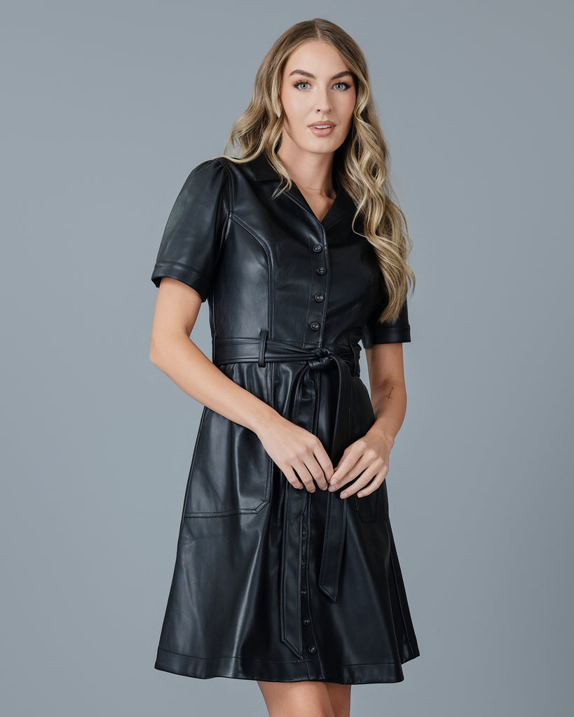 Woman in a black vegan leather short sleeve knee-length dress