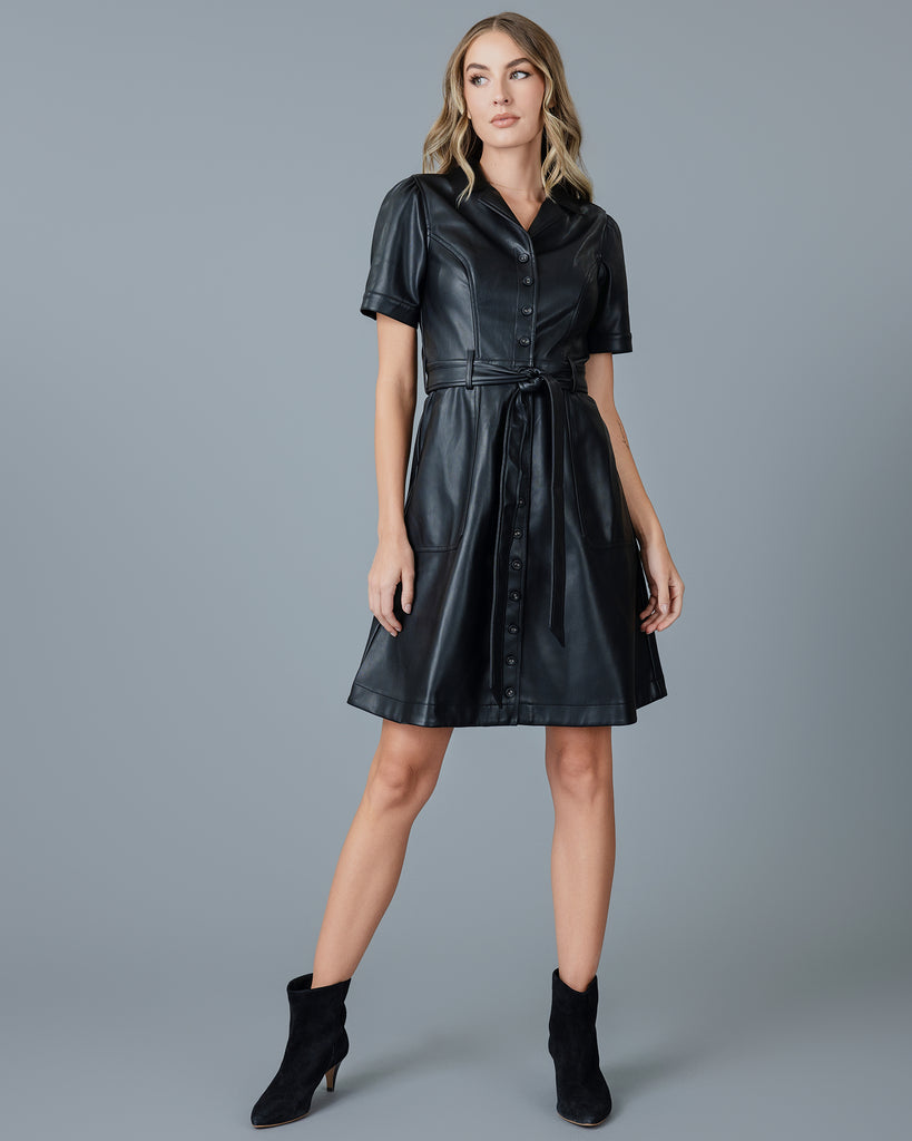 Woman in a black vegan leather short sleeve knee-length dress