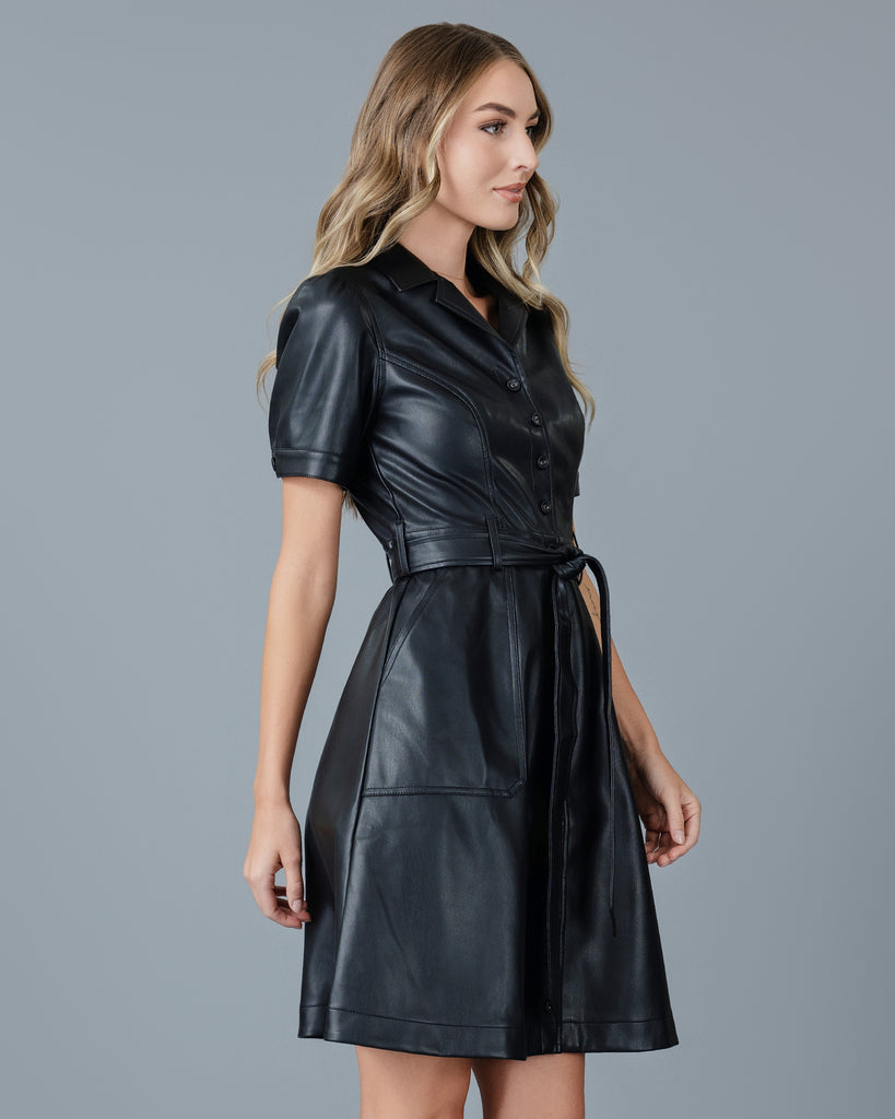 Woman in a black vegan leather short sleeve knee-length dress