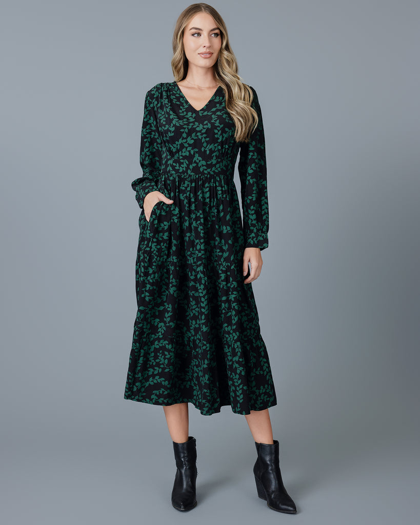 Model wearing a knee-length floral dress with long sleeves