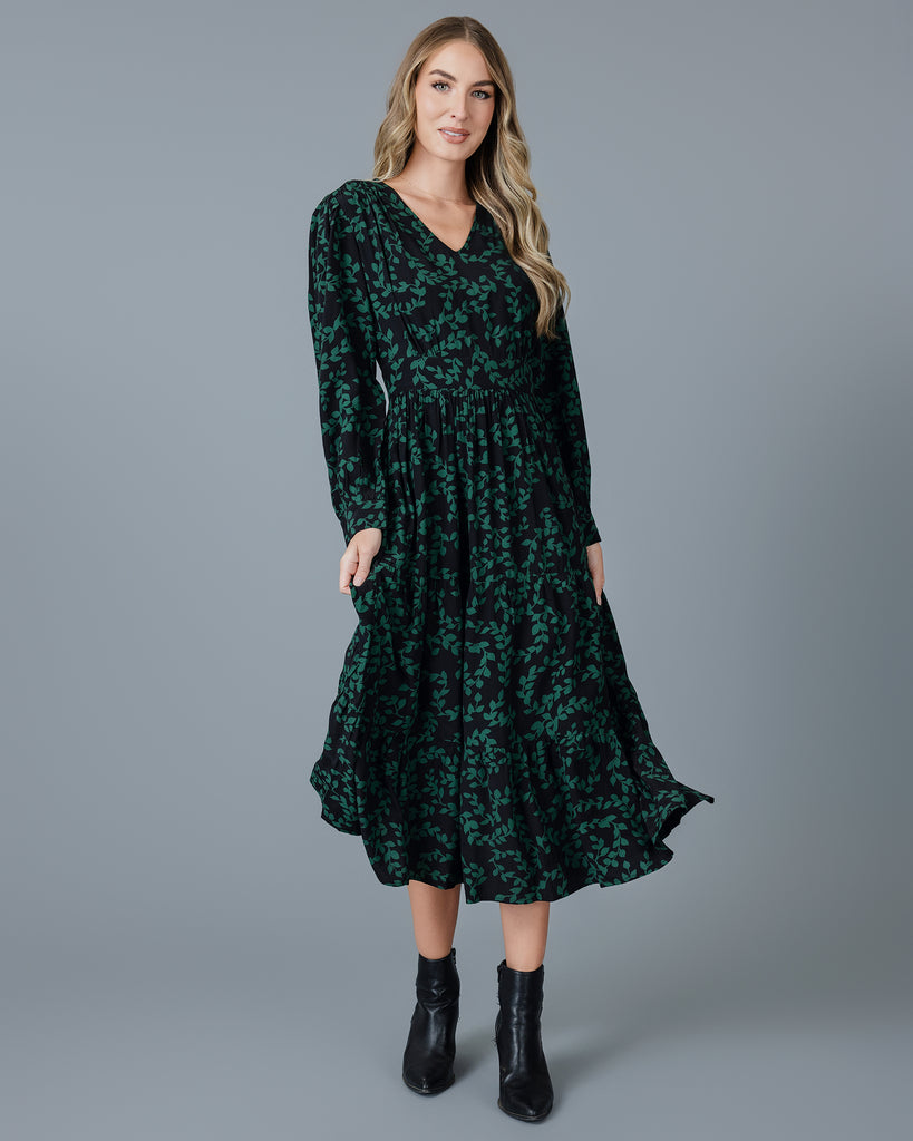 Model wearing a knee-length floral dress with long sleeves