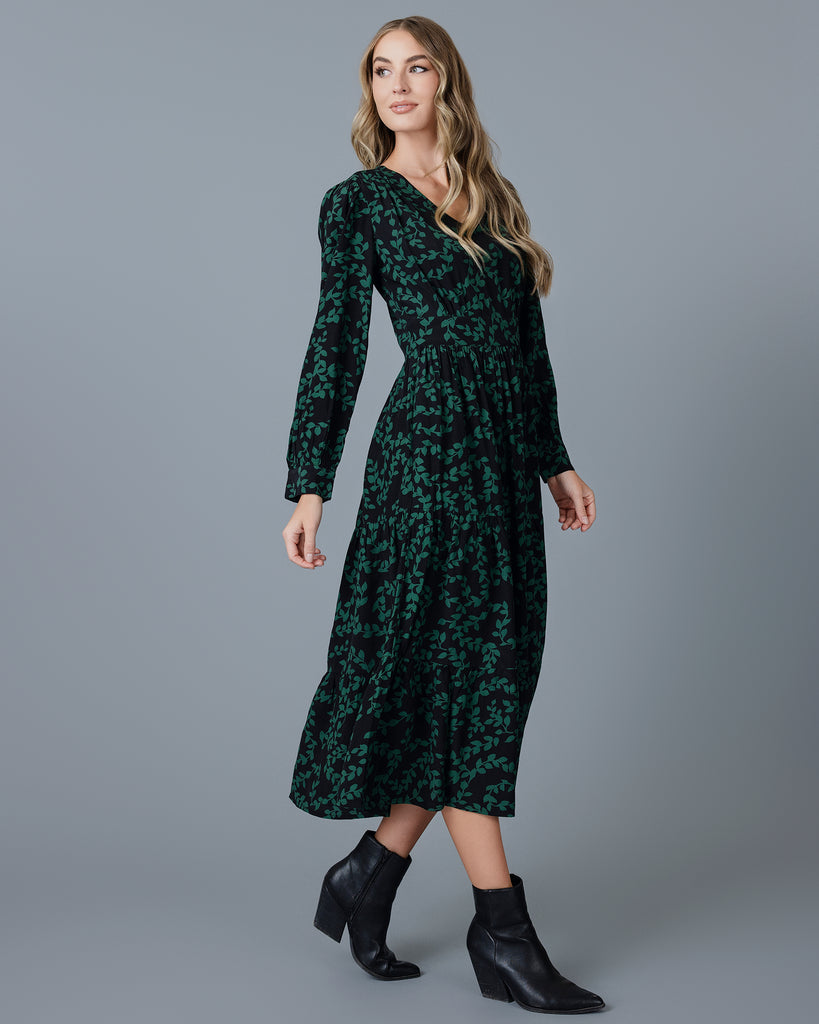 Model wearing a knee-length floral dress with long sleeves