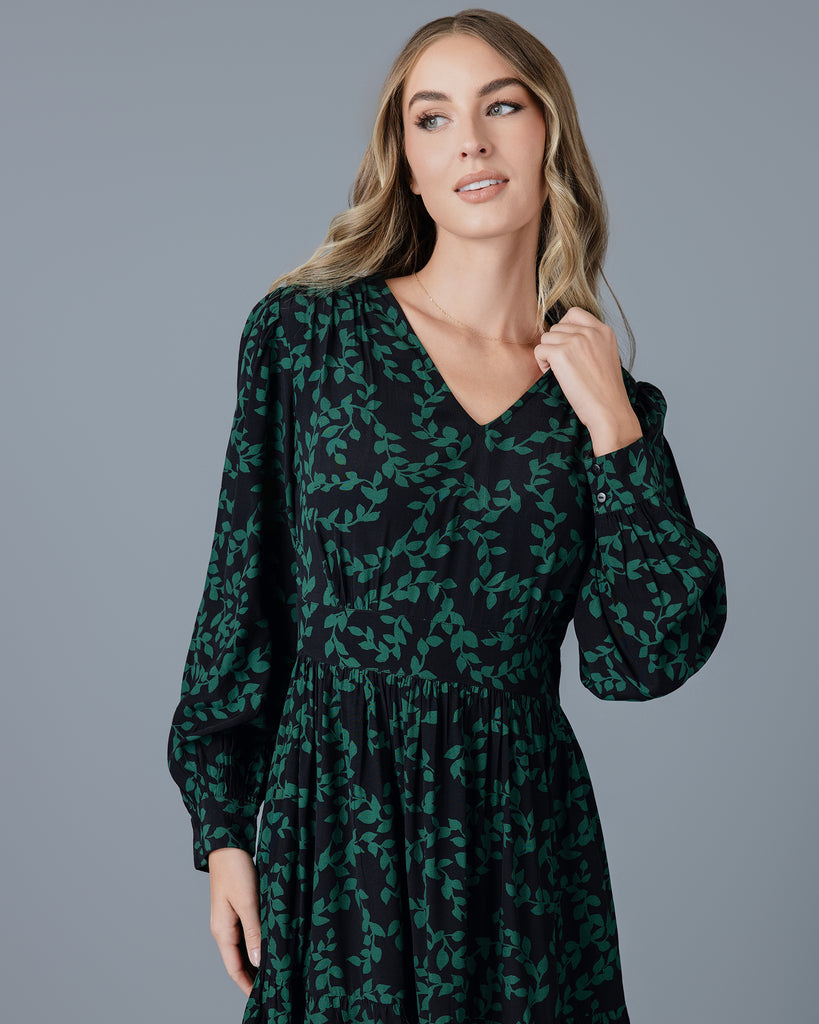 Model wearing a knee-length floral dress with long sleeves