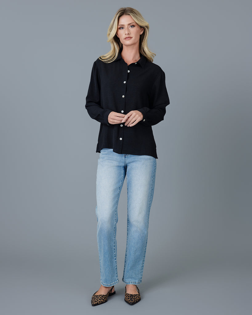 Woman in a black long sleeve buttondown blouse