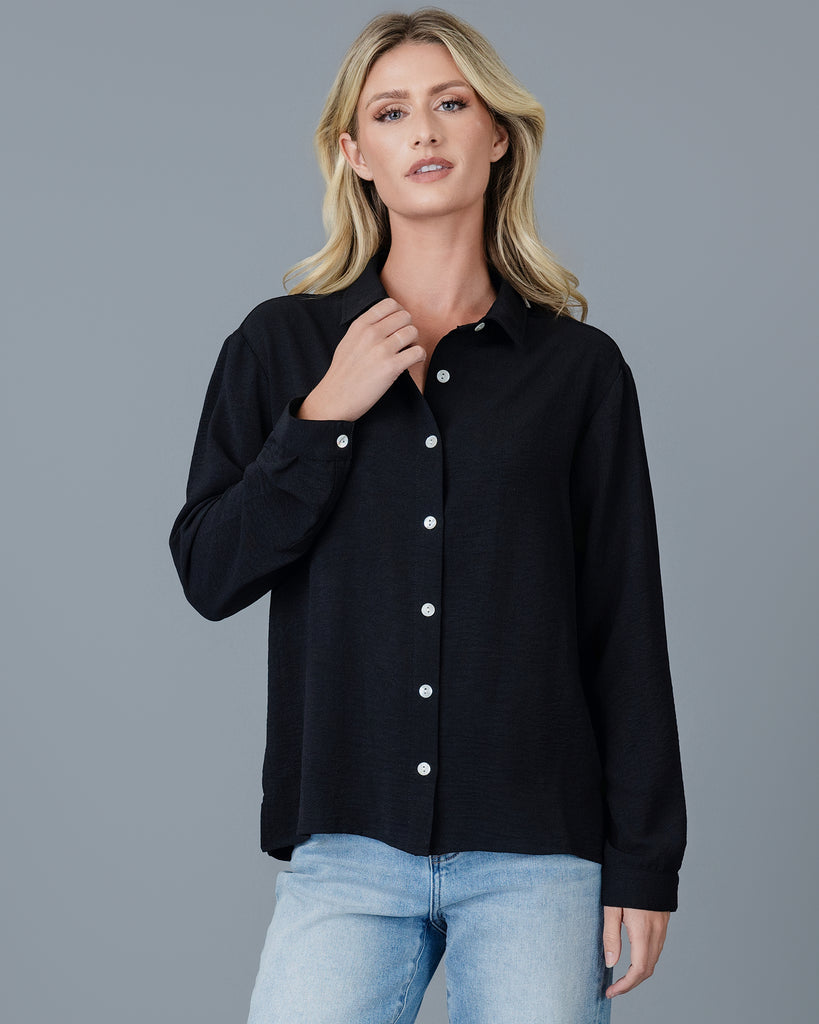 Woman in a black long sleeve buttondown blouse