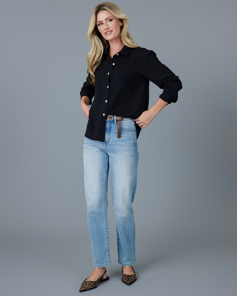 Woman in a black long sleeve buttondown blouse