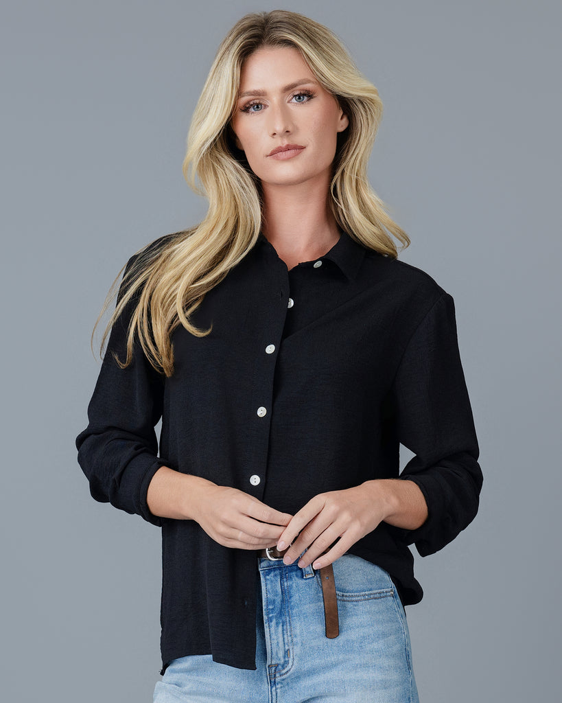 Woman in a black long sleeve buttondown blouse