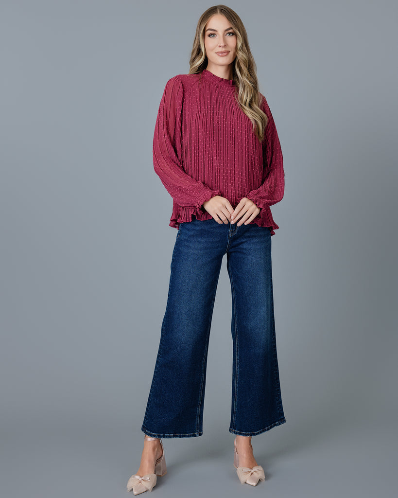 Woman in a red long sleeve pleated blouse