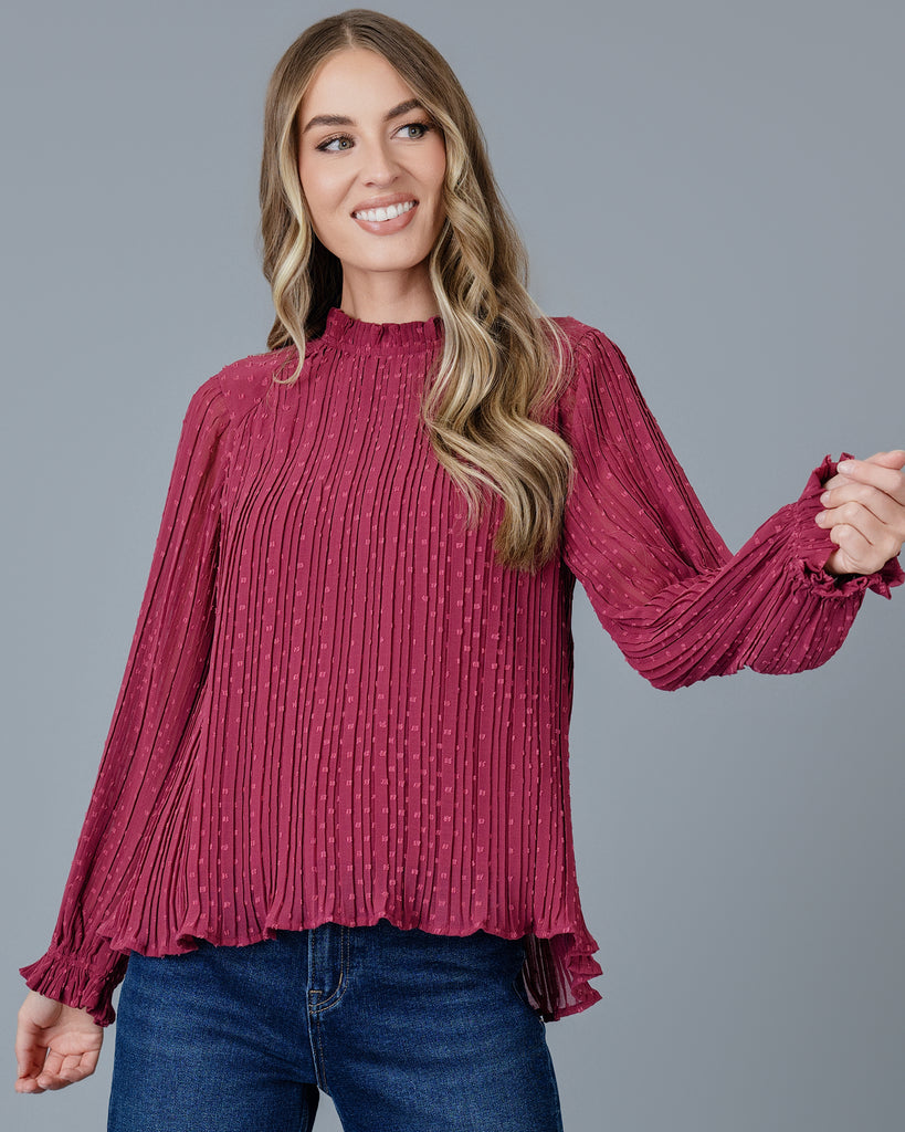 Woman in a red long sleeve pleated blouse