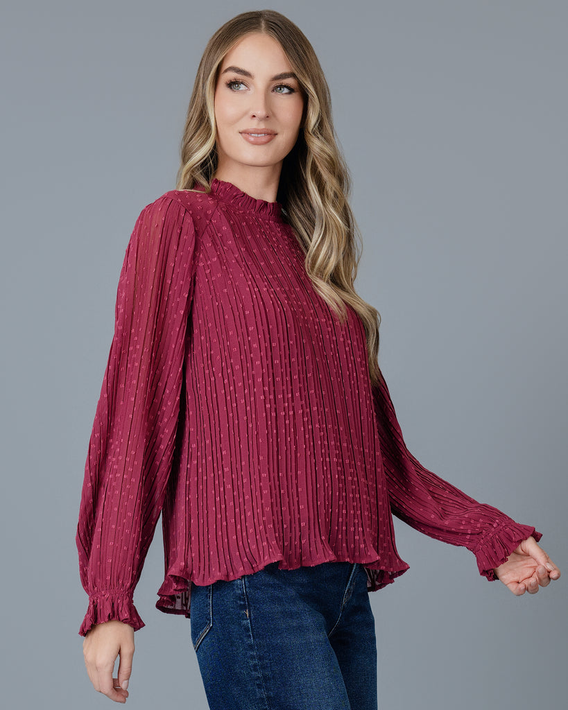 Woman in a red long sleeve pleated blouse