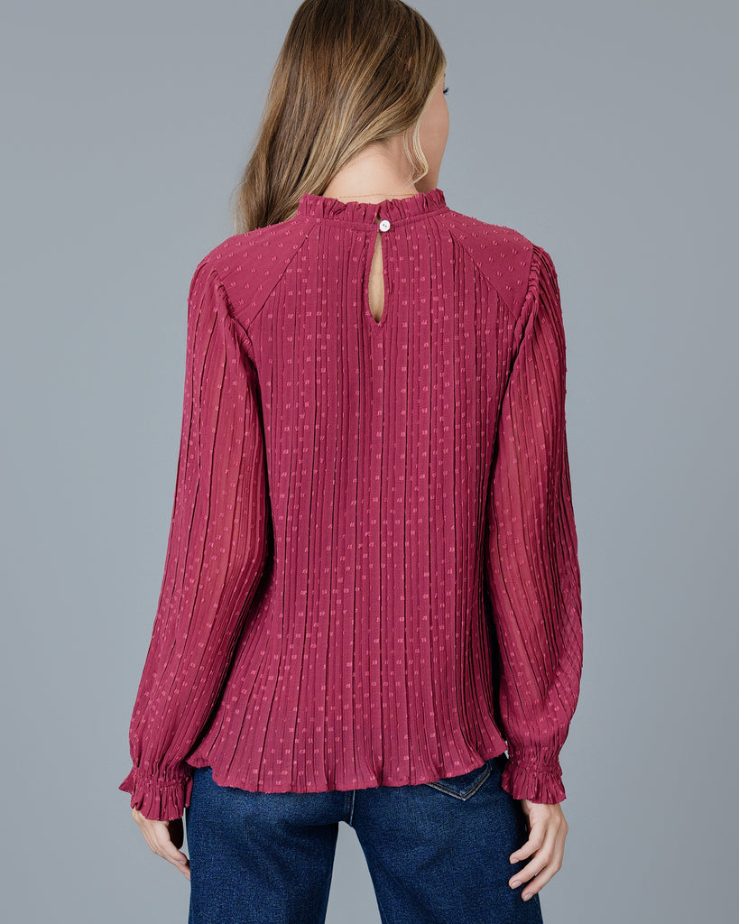 Woman in a red long sleeve pleated blouse