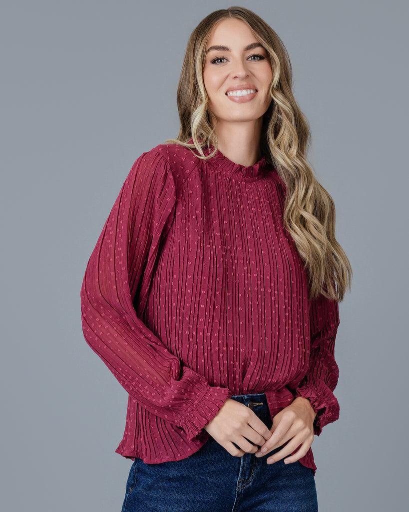 Woman in a red long sleeve pleated blouse