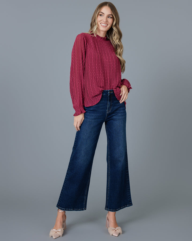 Woman in a red long sleeve pleated blouse