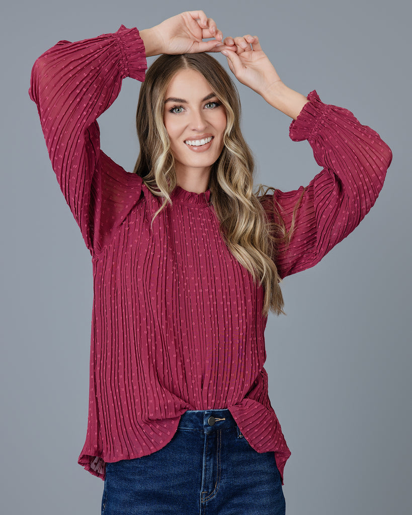 Woman in a red long sleeve pleated blouse