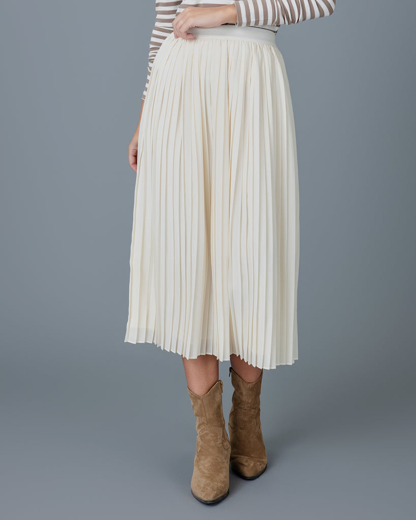 Woman wearing an off-white pleated midi skirt