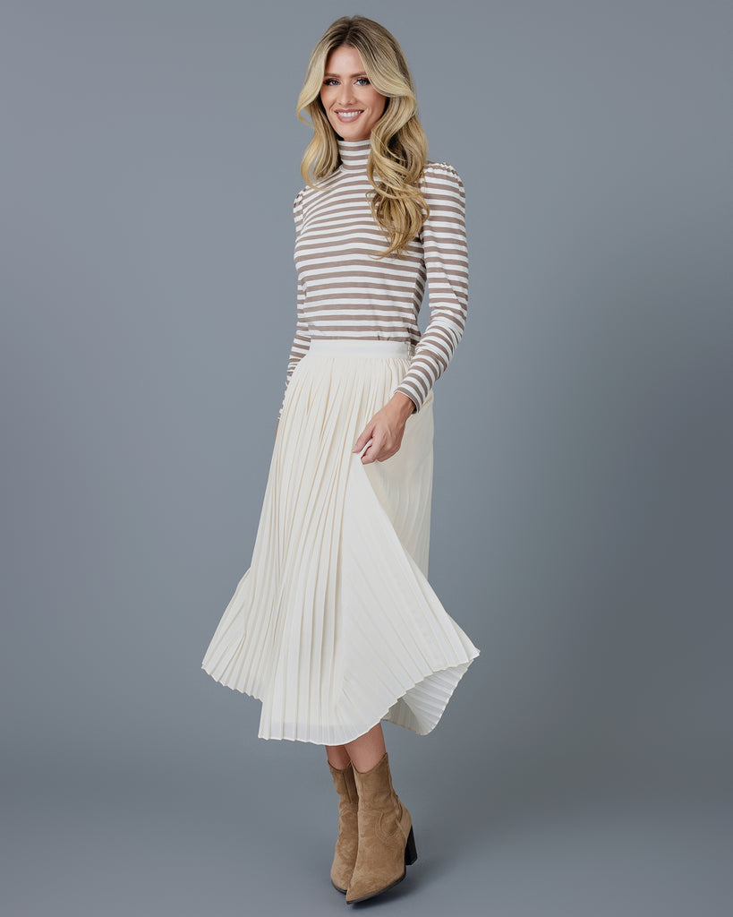 Woman wearing an off-white pleated midi skirt