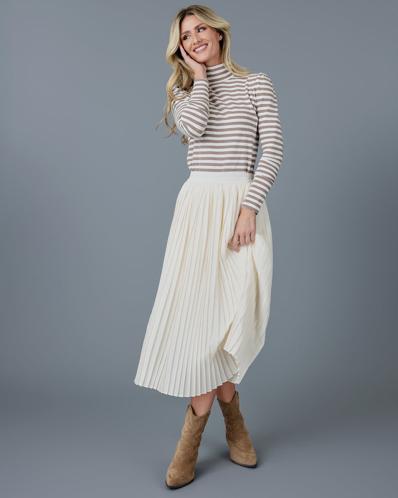 Woman wearing an off-white pleated midi skirt