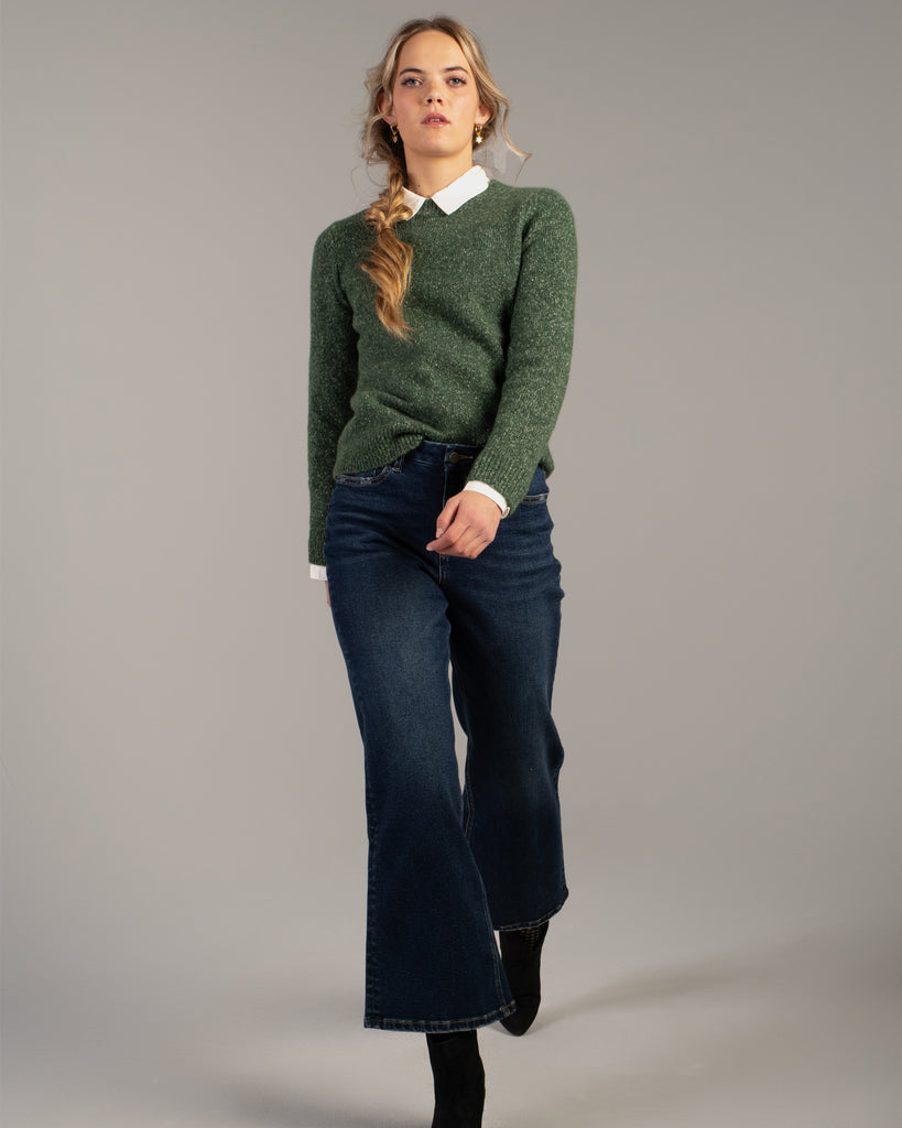 Model wearing dark blue wide leg ankle length denim jeans.