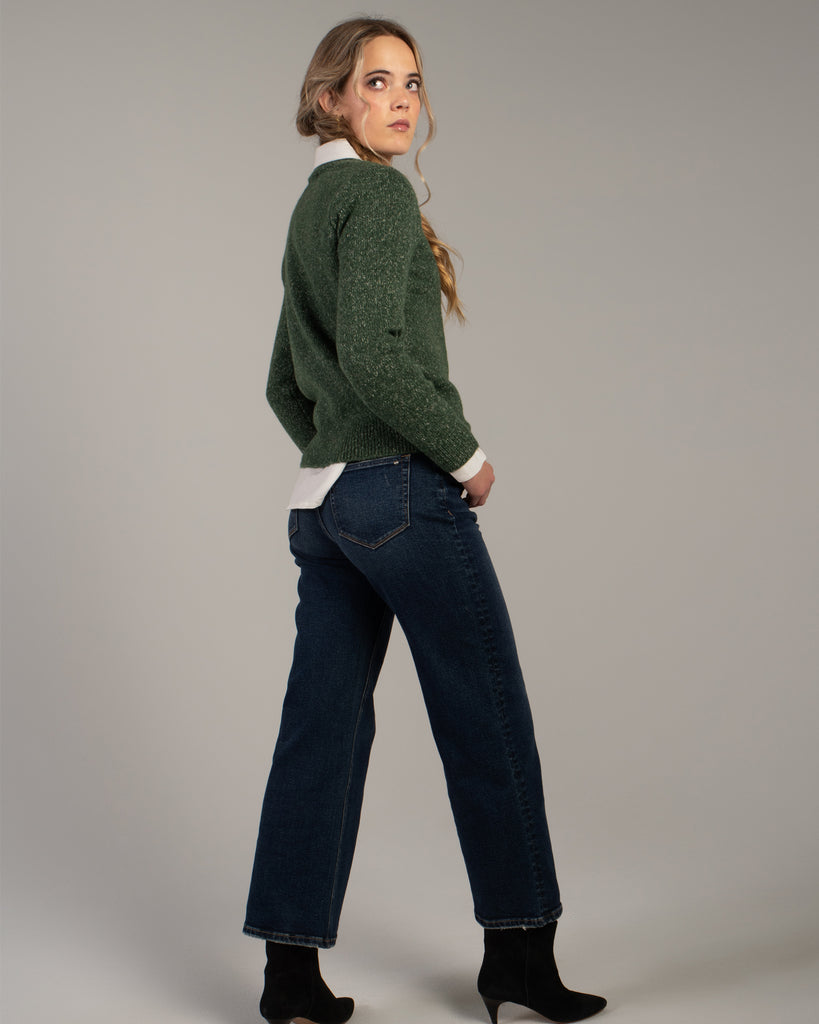 Model wearing dark blue wide leg ankle length denim jeans.