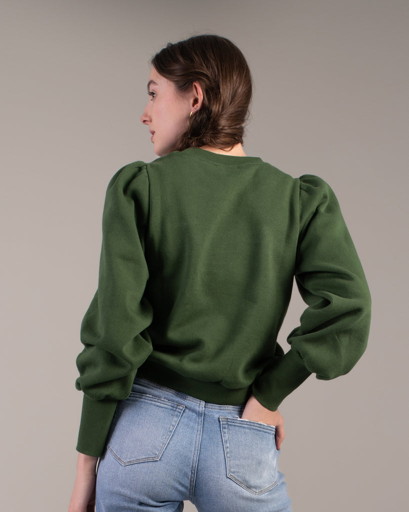 Woman in a green puffed shoulder sweatshirt